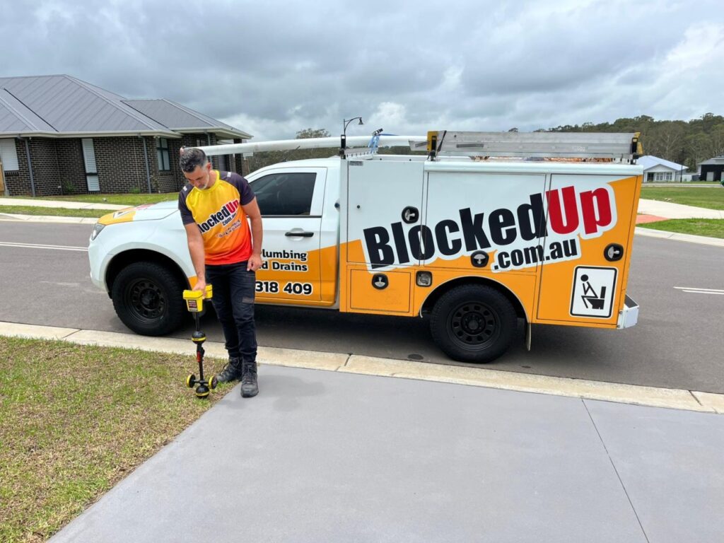 Plumber using a CCTV drain camera to inspect a blocked sewer pipe