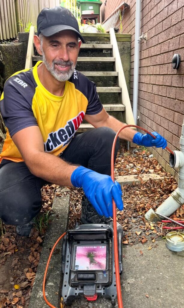 Plumber using CCTV equipment to investigate a sewer blockage